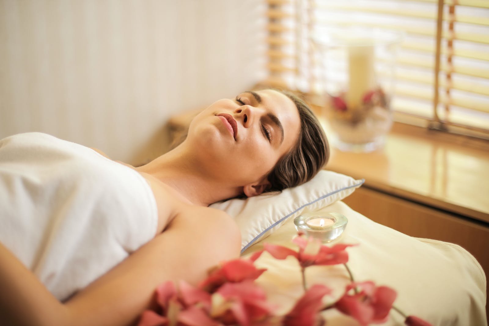 Beauty Spa- A Woman in Wrapped in White Towel Lying on Bed with Eyes Closed